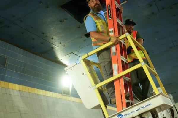 A maintenance worker inspects the leak.